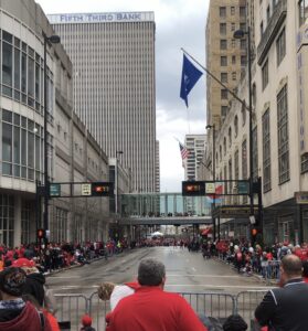 Cincinatti_Parade A street in downtown Cincinnati that is lined with people for a parade. Most people are wearing red shirts.